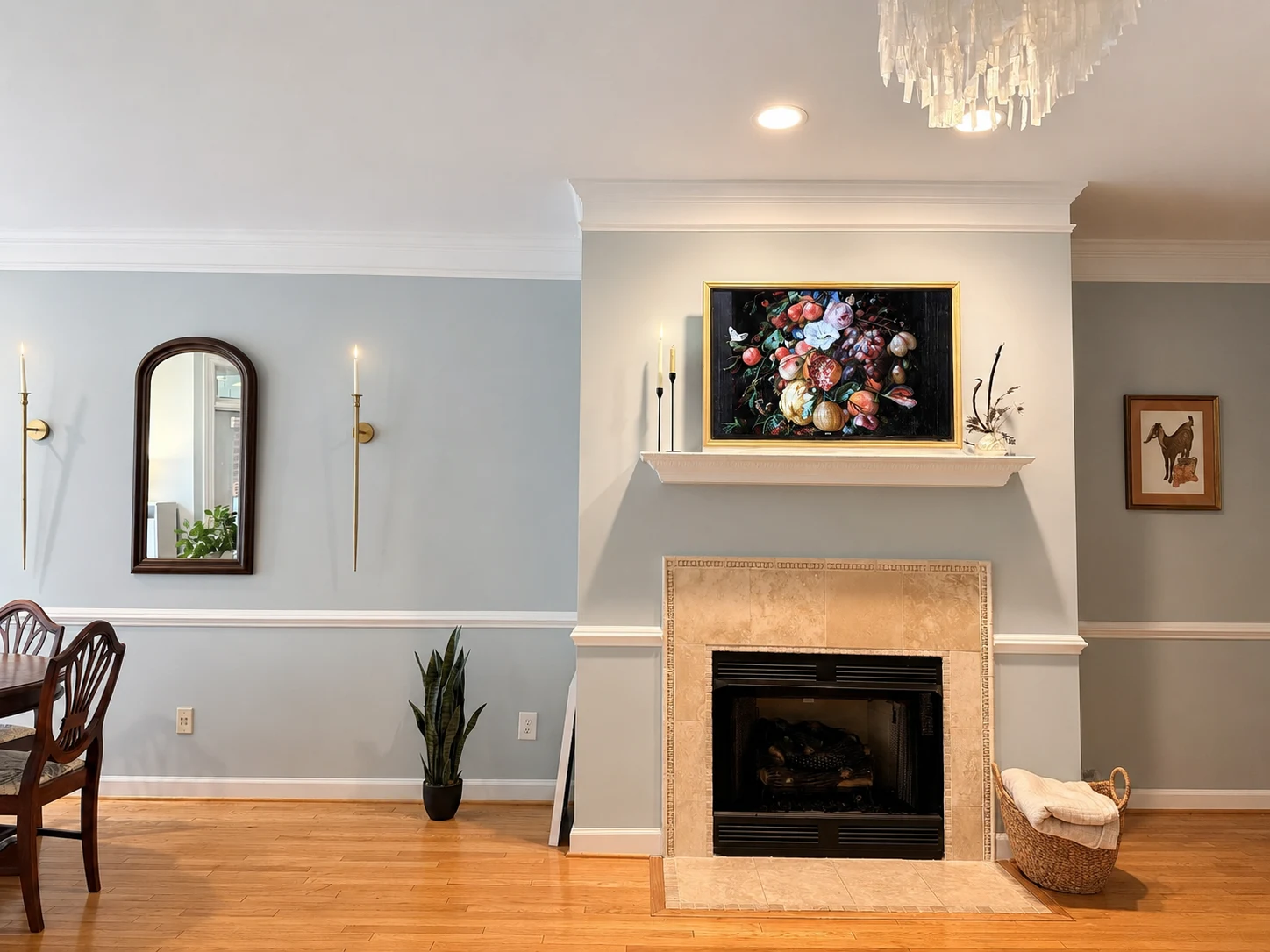 The Lost Poet fireplace with floral artwork above the mantel, blue walls, candle sconces and a view of the dining area