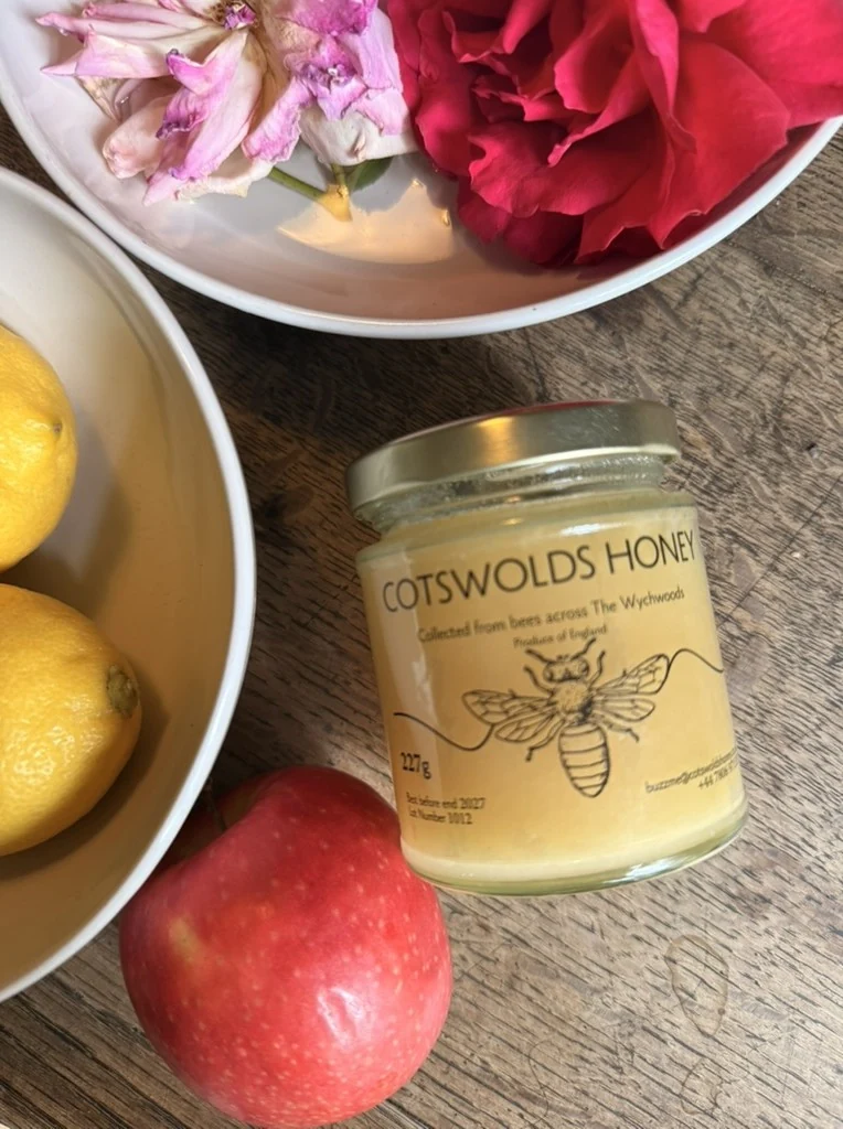 Cotswolds honey, fruit, and flowers in a still-life setting
