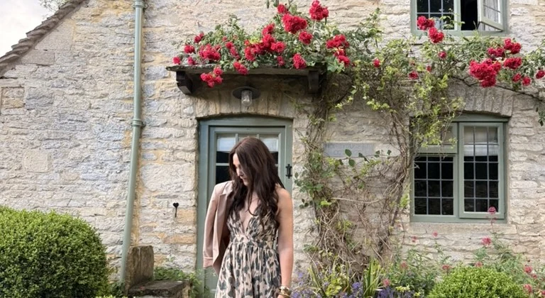 April arriving at a rose-covered stone cottage